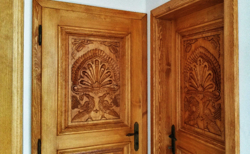 Masivní dveře s ručně vyřezávanými výplněmi s dekorem pávů